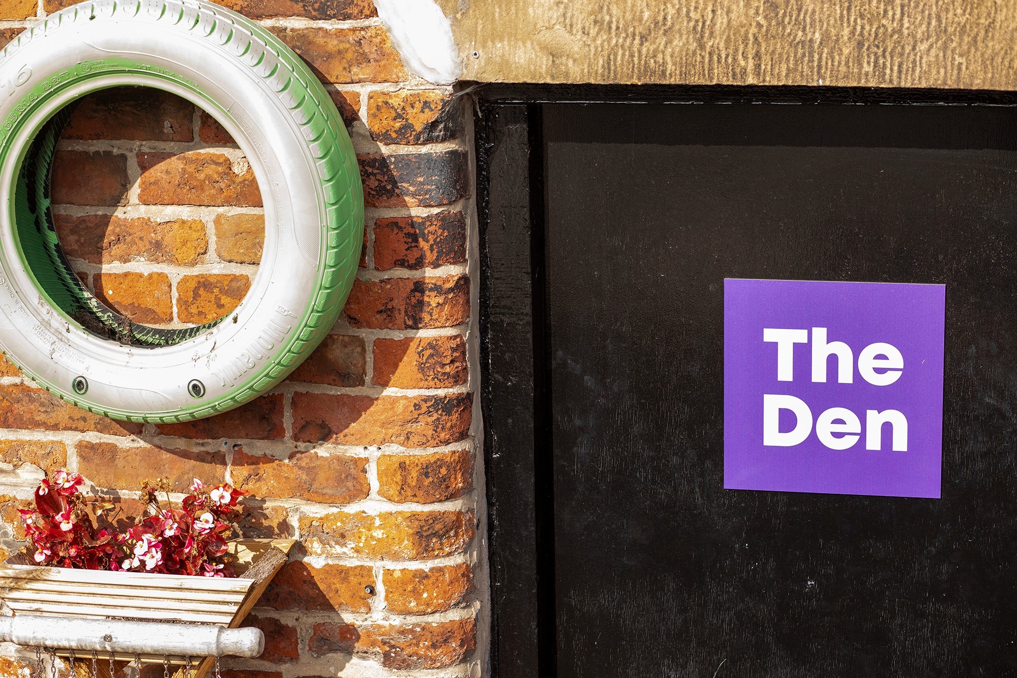 Image of door with signage reading 'The Den'